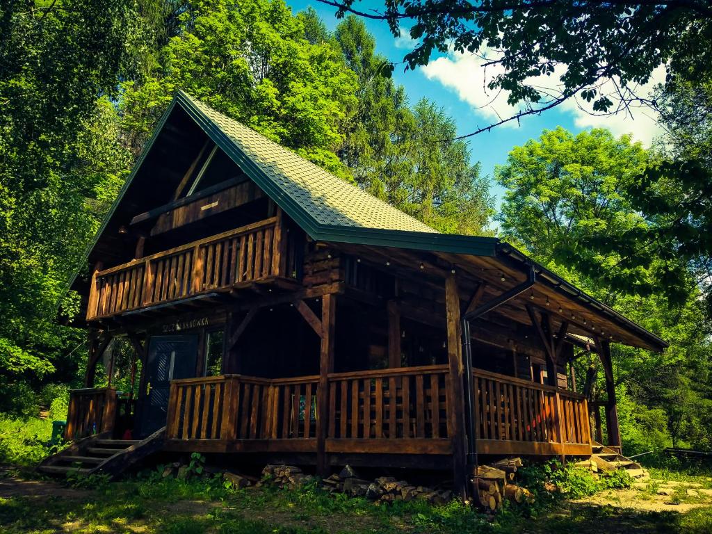 una cabaña de madera en el bosque con techo verde en Szczerbanówka na Maniowie, en Maniów