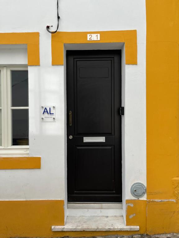 a black door on the side of a building at HOUSE NEXT TO THE THEATER in Évora