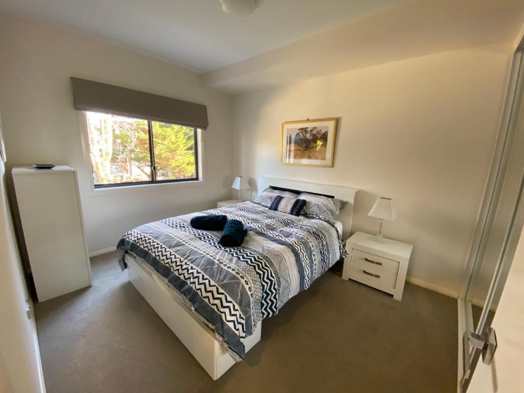 a bedroom with a bed and a window at Quiet apartment adjacent Parliament House in Kingston 