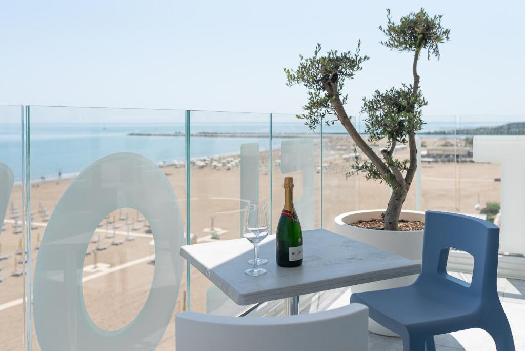 a bottle of wine sitting on a table with two chairs at Unico Hotel Caorle in Caorle