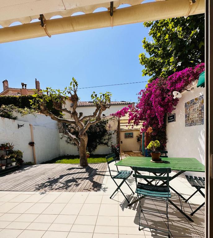 une table et des chaises vertes sur la terrasse dans l'établissement Le jardin du roucas, à Marseille