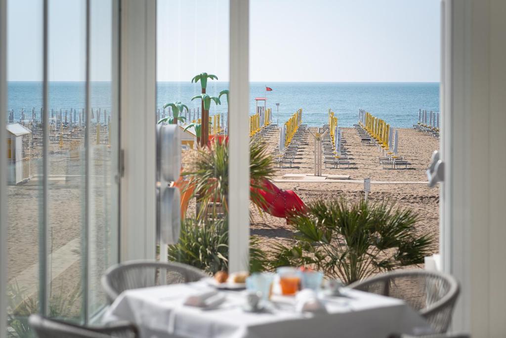 a dining room with a view of the beach at Unico Hotel Caorle in Caorle