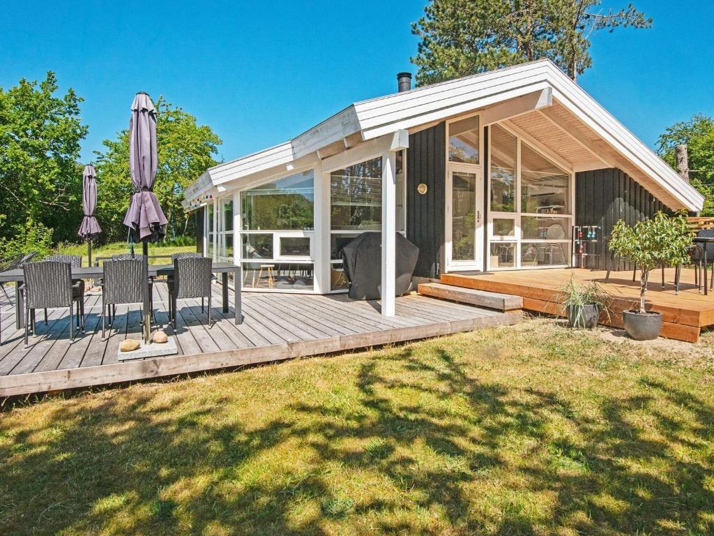 a pavilion with chairs and an umbrella on a deck at Four-Bedroom Holiday home in Ebeltoft 12 in Ebeltoft