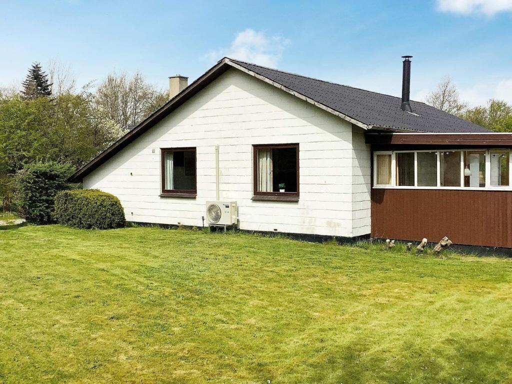 a white house with a grass yard in front of it at 6 person holiday home in Nørre Nebel-By Traum in Nørre Nebel