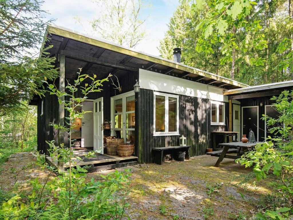 a black and white tiny house in the woods at 4 person holiday home in Bryrup in Bryrup