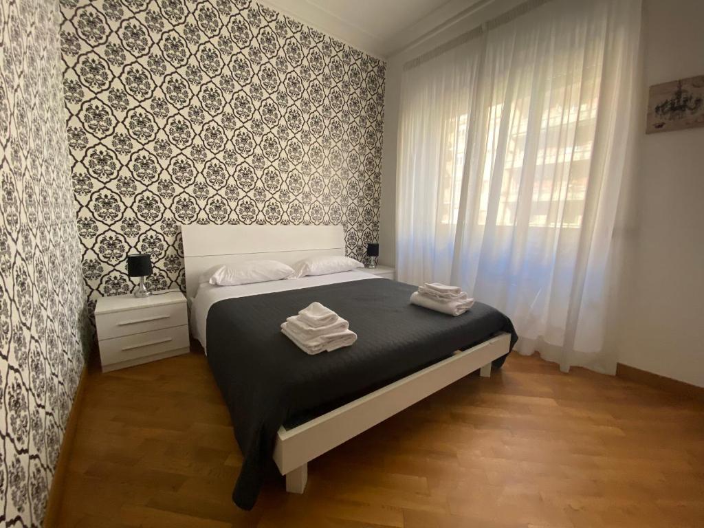 Schlafzimmer mit einem Bett mit schwarzweißer Tapete in der Unterkunft Flaminio Holidays in Rom