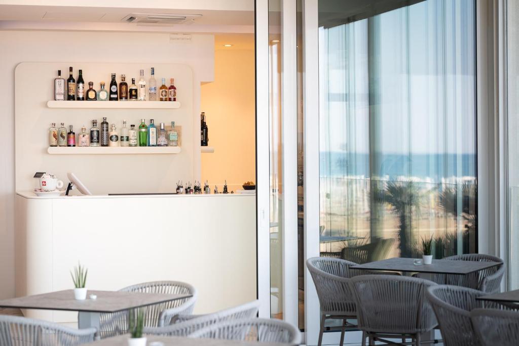 a restaurant with tables and chairs and a window at Unico Hotel Caorle in Caorle