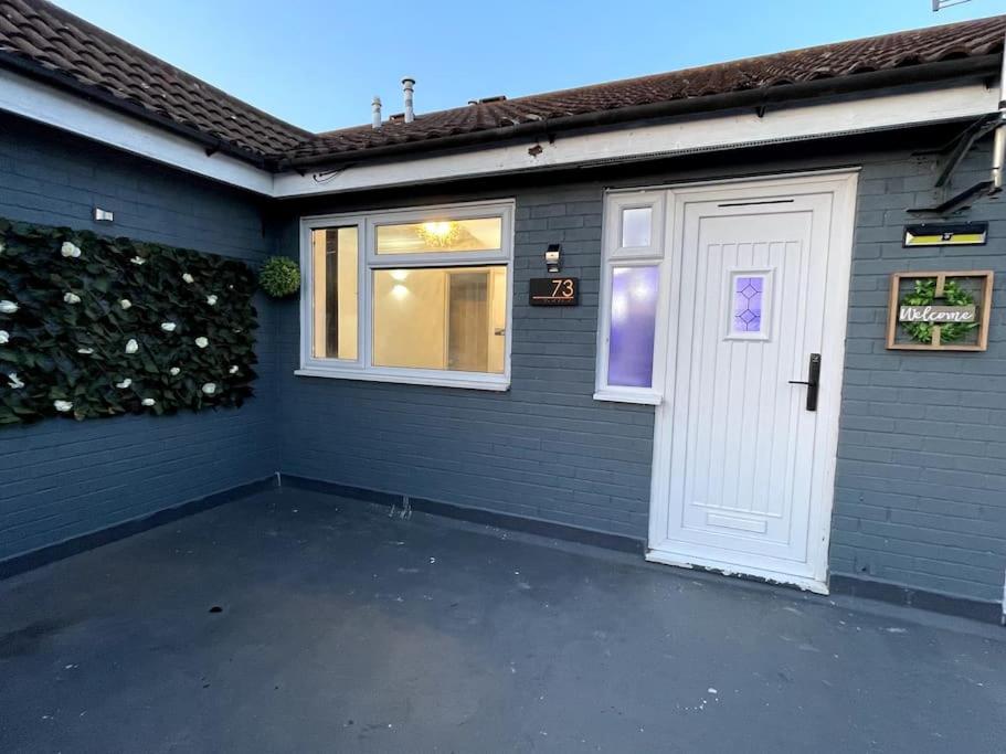 a garage with a white door and a window at Chic 2 Bedroom Flat in Trimley Heath