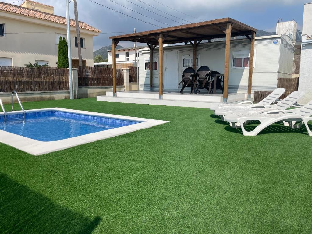 un patio con piscina, sillas y cenador en Chalet-home familiar "CAL DENVER" "Pet friendly", en Sant Carles de la Ràpita
