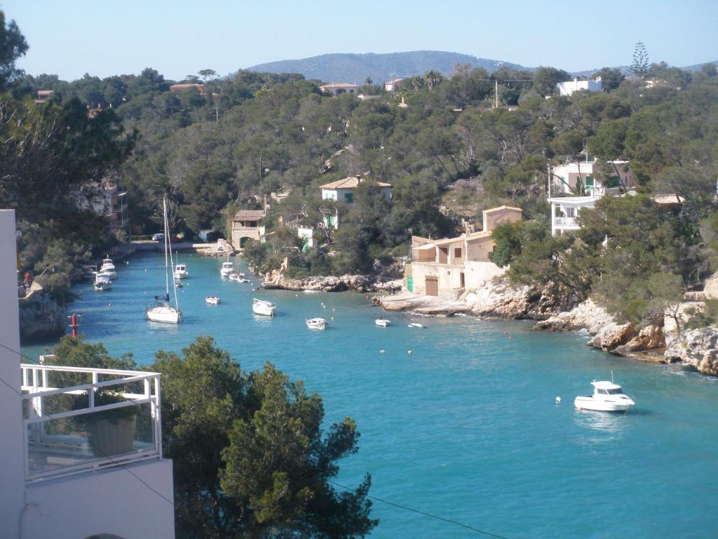 een rivier met boten in het water en gebouwen bij Chalet Cala Figuera in Cala Figuera