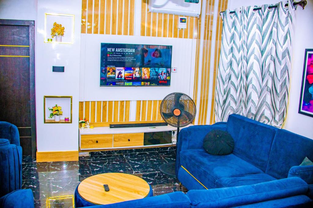 uma sala de estar com um sofá azul e uma mesa em Homey 2-Bed-Apt 24HRS POWER & Unlimited Internet Access em Lagos