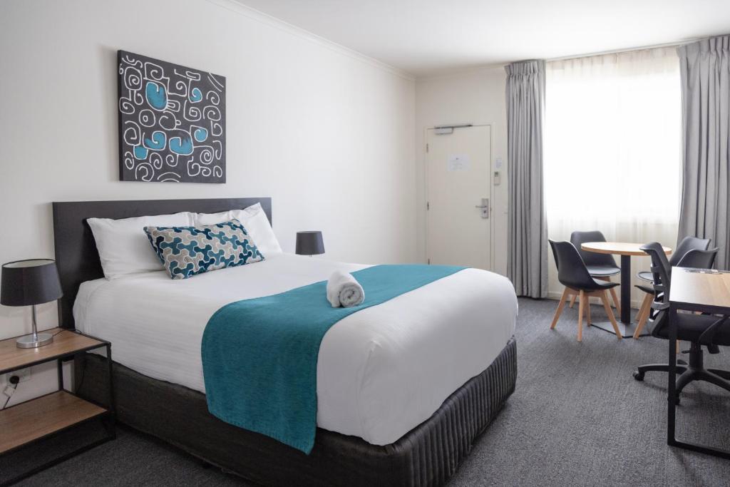 a hotel room with a bed and a table and chairs at Bairnsdale International in Bairnsdale