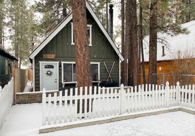 a white picket fence in front of a house at Shady Pine Cottage - This adorable cabin is the perfect getaway for your next stop in the mountains! in Big Bear City