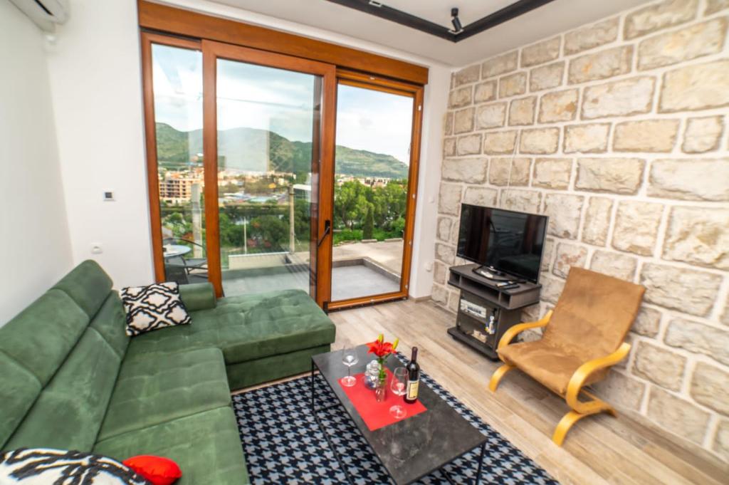 a living room with a green couch and a television at Apartman Roccia in Trebinje