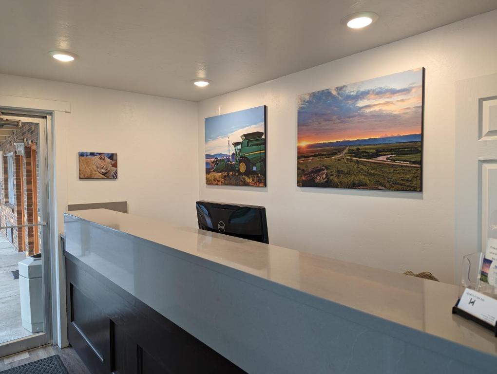 an office cubicle with a desk and paintings on the wall at Henry's Fork Inn in Saint Anthony