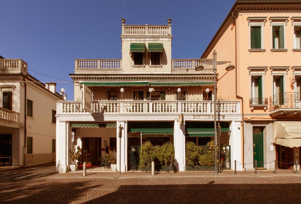 a large white building with a balcony on a street at Hotel Kappa in Mestre