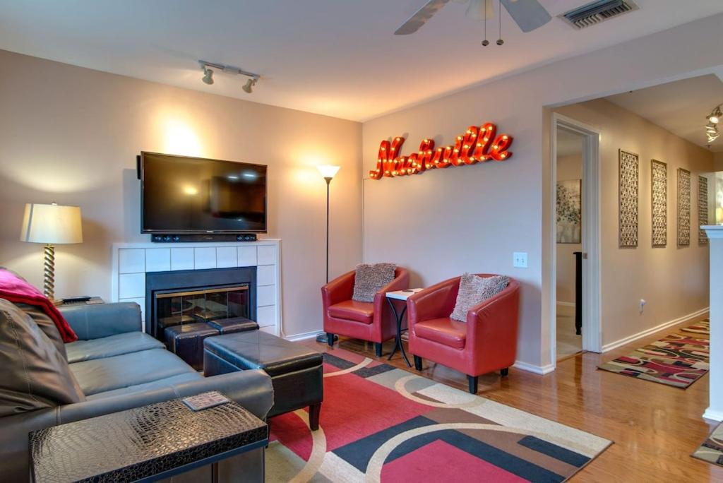 a living room with a couch and chairs and a fireplace at Heart of Downtown/Walk to BROADWAY & THE ACTION/BARS/Music Venues/Honky Tonks! in Nashville