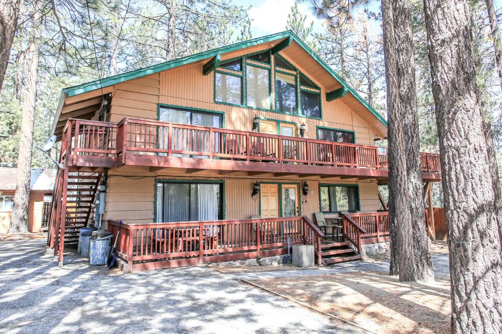 een huis met een groot terras in het bos bij Summit Escape B - Rustic cabin with a hot tub and barbecue! Wood fireplace! Walk to Slopes! in Big Bear Lake
