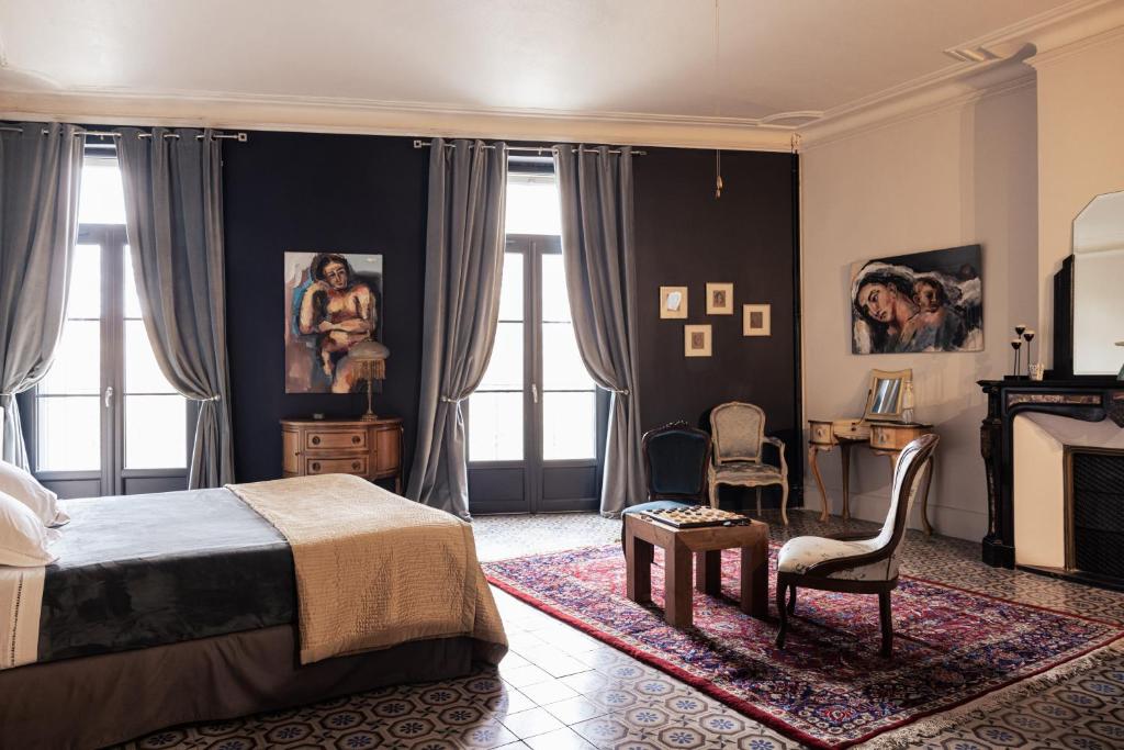 a bedroom with a bed and a desk and a chair at La promesse de l aude in Sallèles-dʼAude