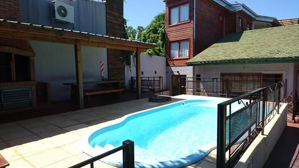 een zwembad in de achtertuin van een huis bij Hotel Los Lapachos in Puerto Iguazú
