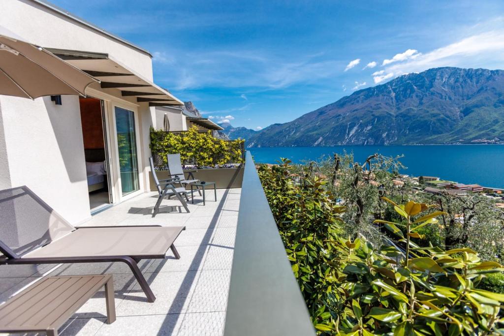 balcón con vistas al agua y a las montañas en LLAC Living Nature Hotel, en Limone sul Garda