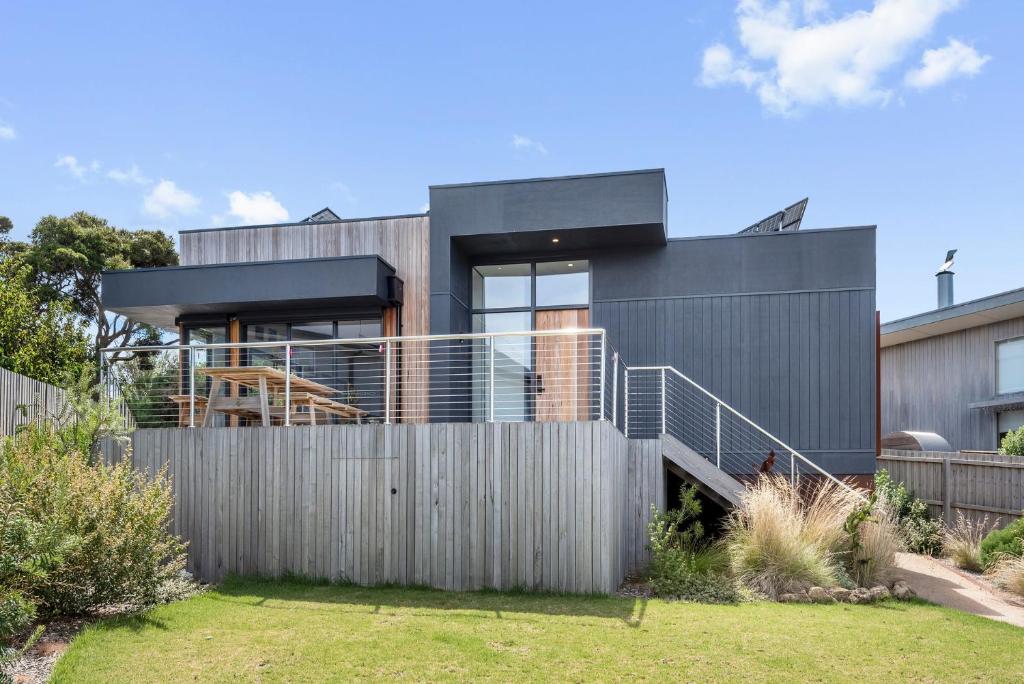 a modern house with a fence in front of it at Stage 1 in Point Lonsdale