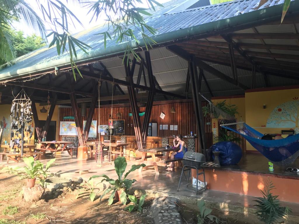 une femme assise dans un hamac dans un bâtiment dans l'établissement Luminosa Uvita Hostel, à Uvita