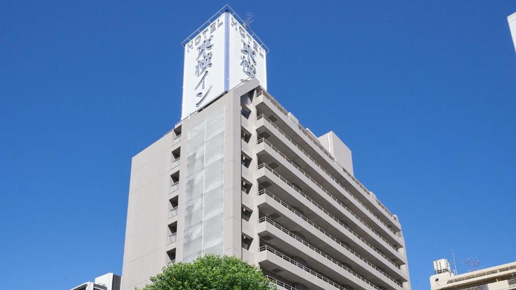 名古屋的住宿－Toyoko Inn Nagoya Marunouchi，一座高大的白色建筑,顶部有钟楼