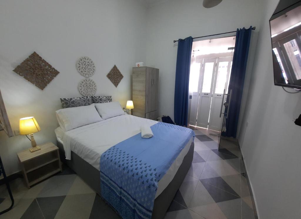 een slaapkamer met een bed, een raam en een televisie bij GS 996 in Cartagena