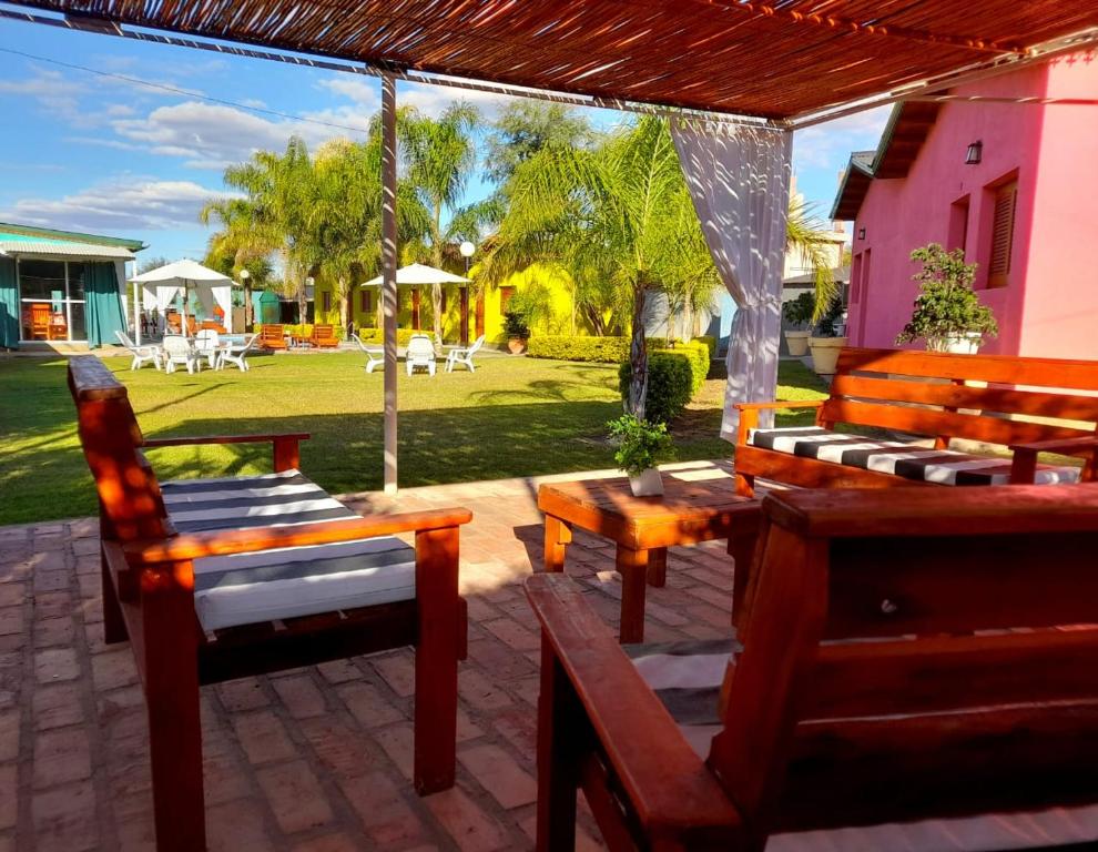 a patio with wooden benches and tables and a yard at Cabañas Puertas del Sol in La Rioja