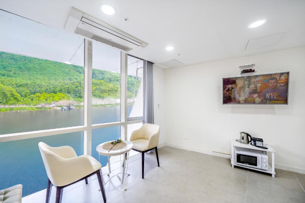 a living room with a view of the water at YJ Hotel in Gapyeong