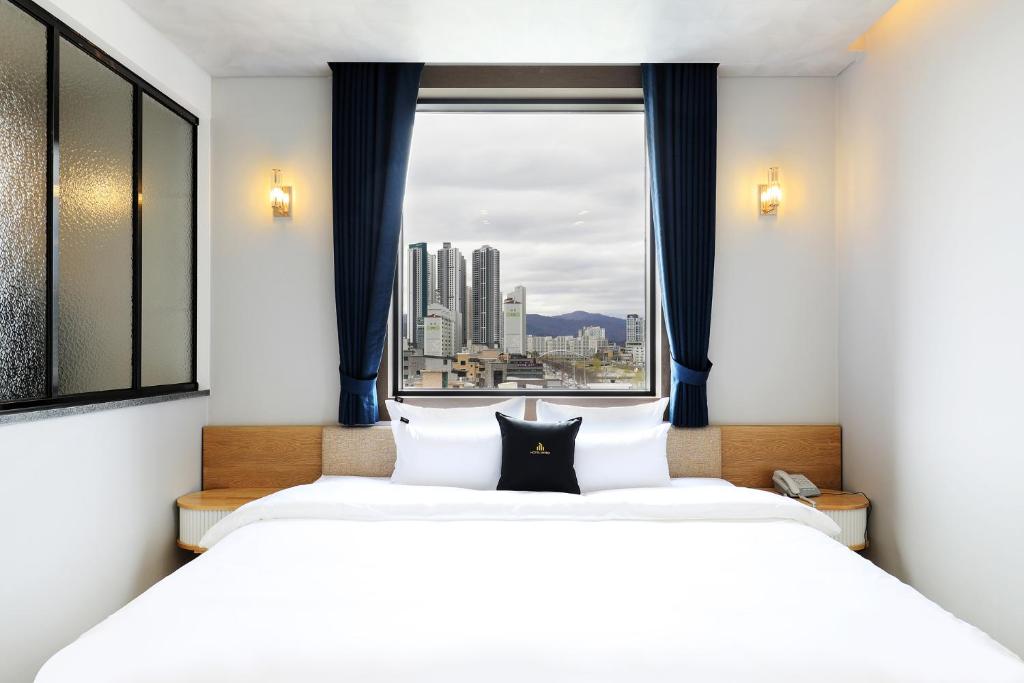 a bedroom with a large bed with a window at Hotel Intro Chuncheon in Chuncheon