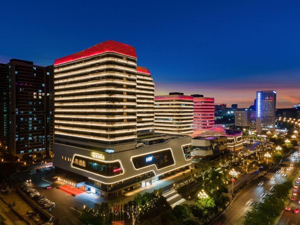 Livetour Hotel Luogang Science City Guangzhou في قوانغتشو: مبنى كبير بسقف احمر في مدينة