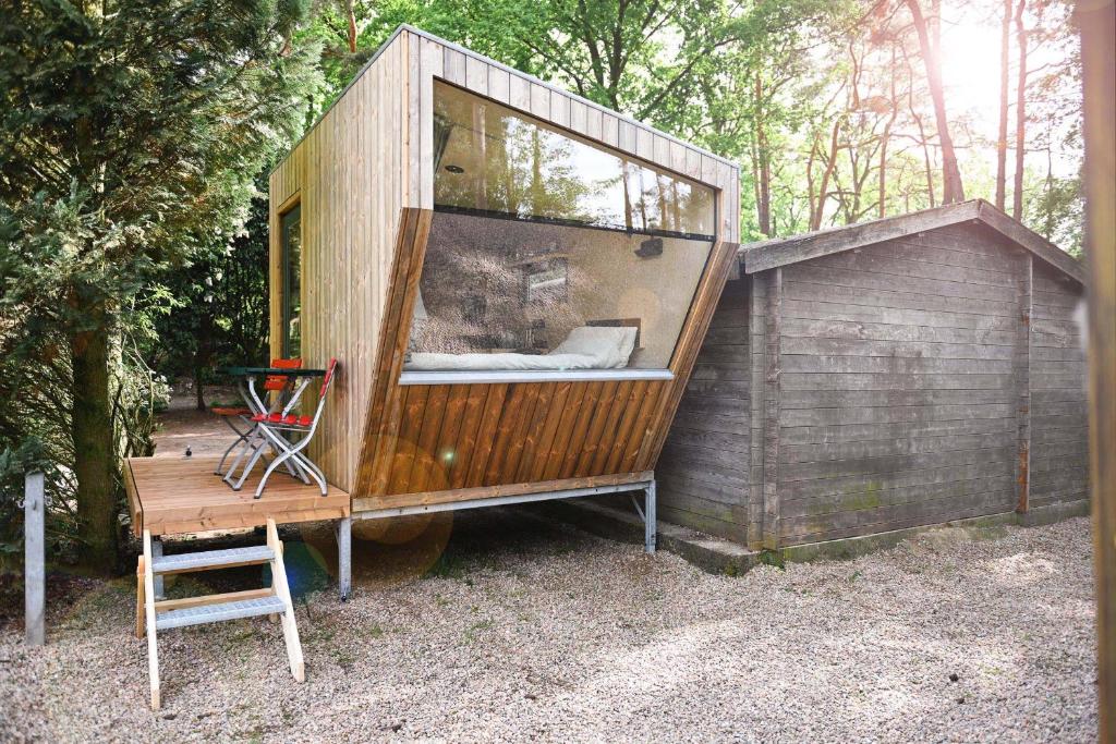 Casa pequeña con ventana grande y silla en Sleep Space - Green Tiny Spot Steinhuder Meer en Neustadt am Rübenberge