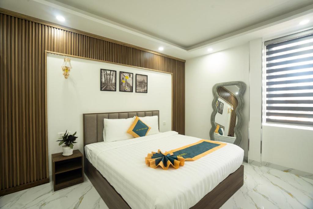 ein Schlafzimmer mit einem großen Bett mit einer Schleife darauf in der Unterkunft BinBin Phúc Dalat Hotel in Da Lat