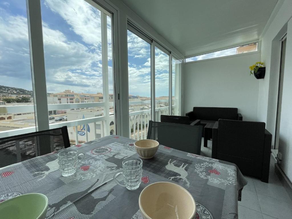 une table de salle à manger avec vue sur un balcon dans l'établissement 2 pièces mezzanine, parking privé, animaux admis - FR-1-338-475, à Sète