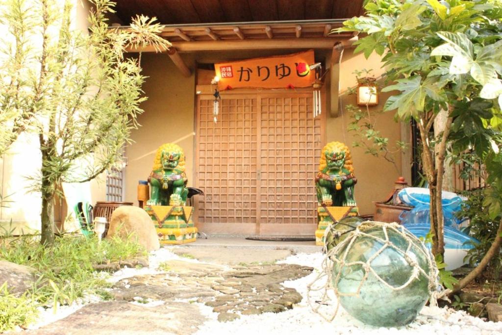 a house with a sign on the front of it at Okinawa Minshuku Kariyushi in Shirahama