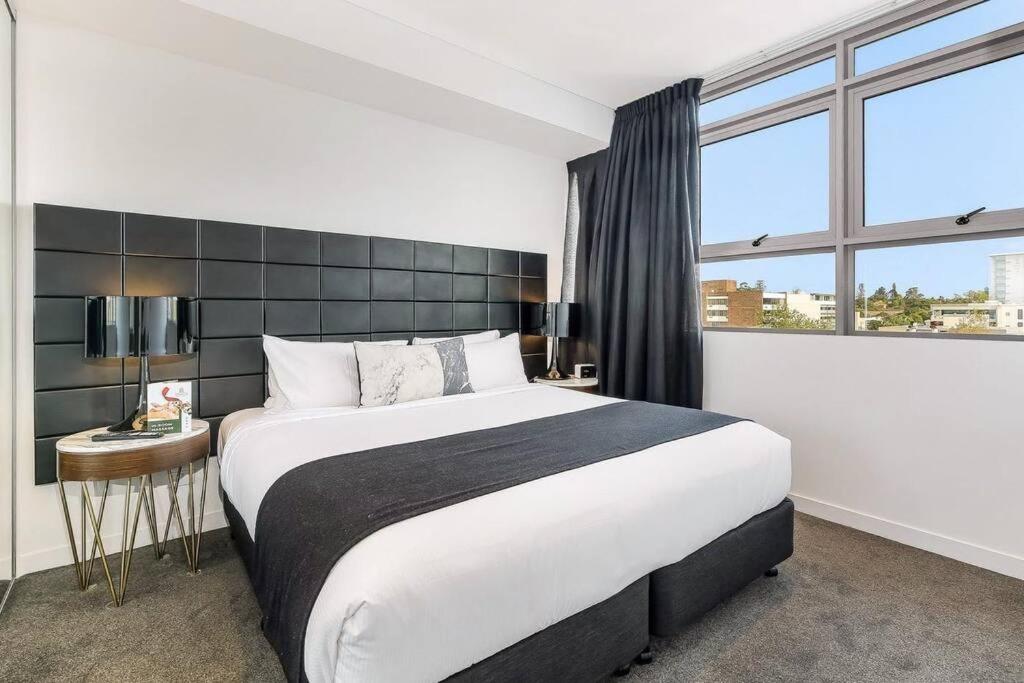 a bedroom with a large bed and a large window at Chatswood CBD 2BR l Balcony l Parking l Office in Sydney