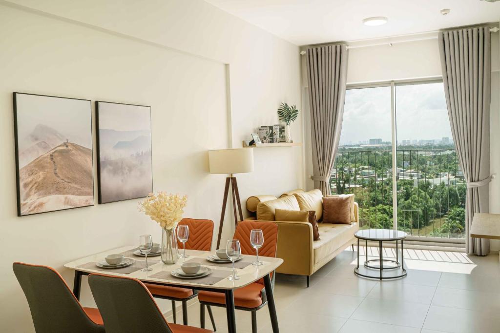 uma sala de estar com uma mesa e um sofá em Westgate Apartment- 2N House em Ho Chi Minh
