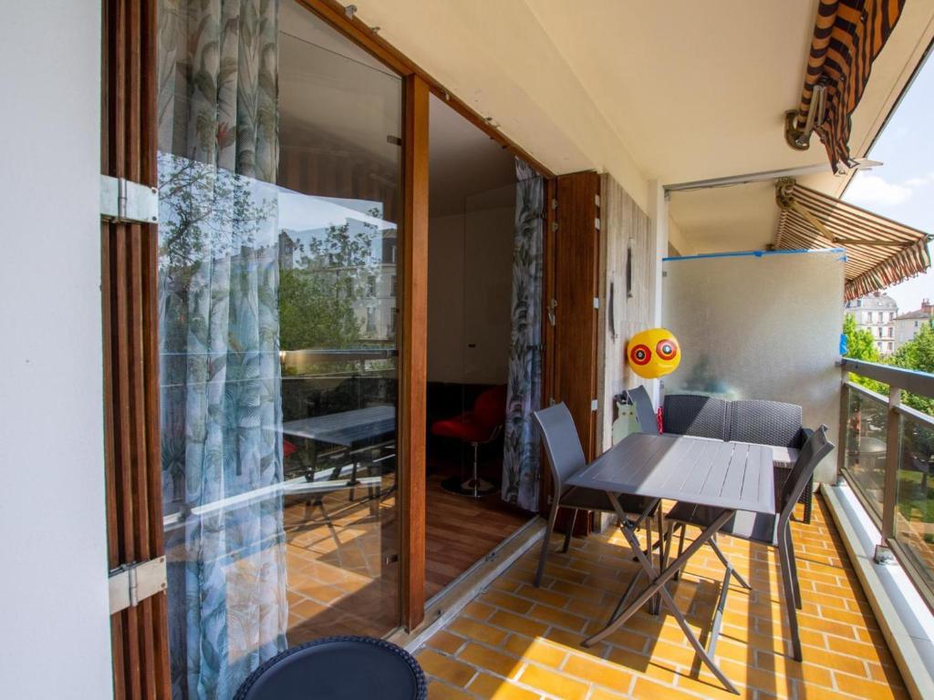 une chambre avec un balcon avec une table et des chaises dans l'établissement Élégant 3 pièces avec balcon, centre de Périgueux, proche cathédrale et marché - FR-1-616-326, à Périgueux