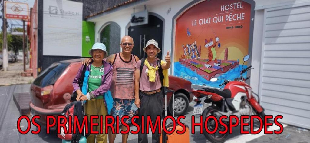 un grupo de tres personas de pie junto a una motocicleta en "LE CHAT QUI PECHE" Hostel a 150 metros da PRAIA de PAJUCARA, en Maceió