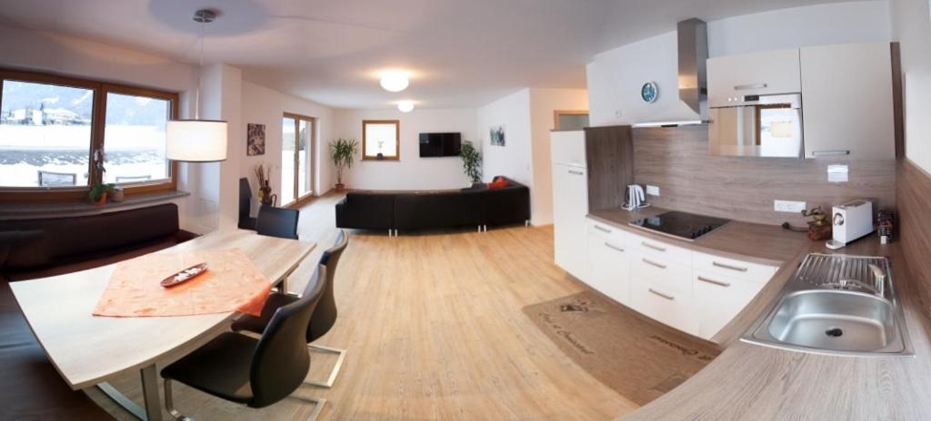 cocina y sala de estar con mesa y fregadero en Appartement Dominik, en Uderns