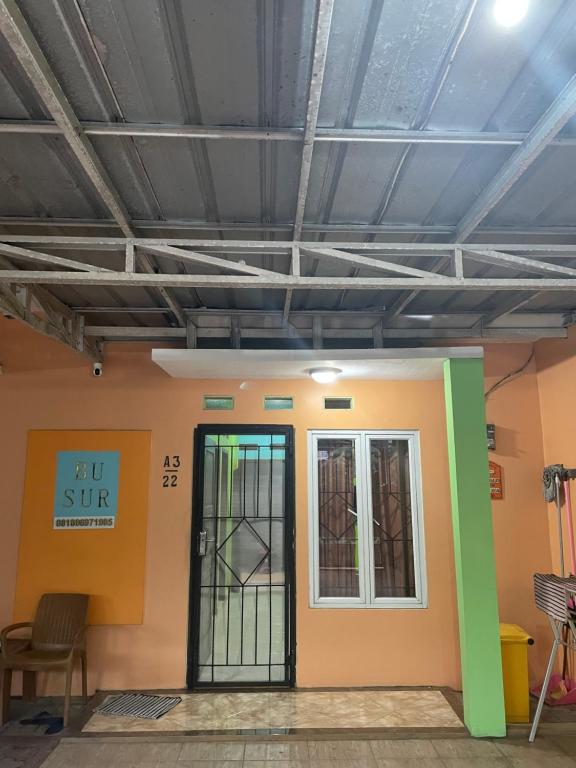 une chambre avec une porte et un bâtiment dans l'établissement Bu Sur Homestay, à Bogor