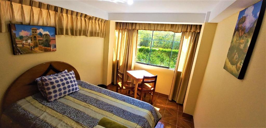 una camera con letto, tavolo e finestra di Carlos Guest House 2 Cusco a Cuzco