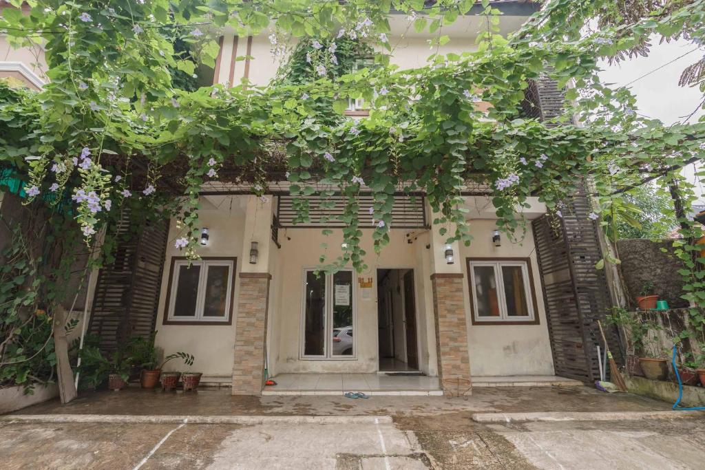 an old house with a bunch of trees in front of it at KoolKost Syariah @ Citraland Puri Serang in Serang