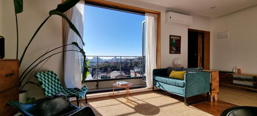 een woonkamer met een bank en een groot raam bij Naksan Balcony in Seoul