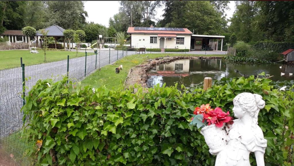 Una statua di una ragazza e un laghetto in un parco di Cosy-Cottage a Hechtel-Eksel
