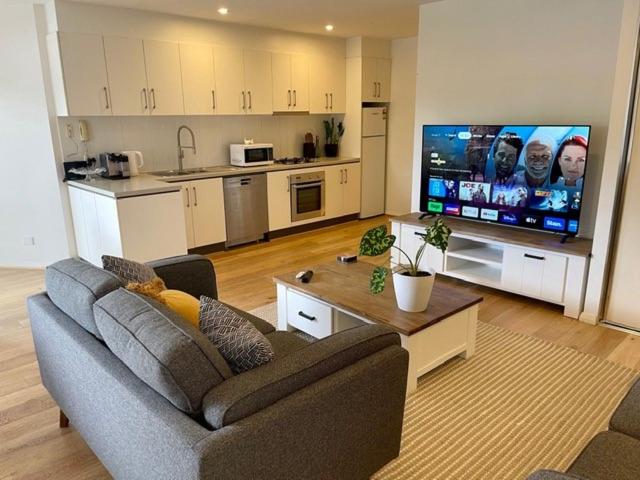 a living room with a couch and a large screen tv at Andy & Anna's Weekend Hideaway in Newcastle