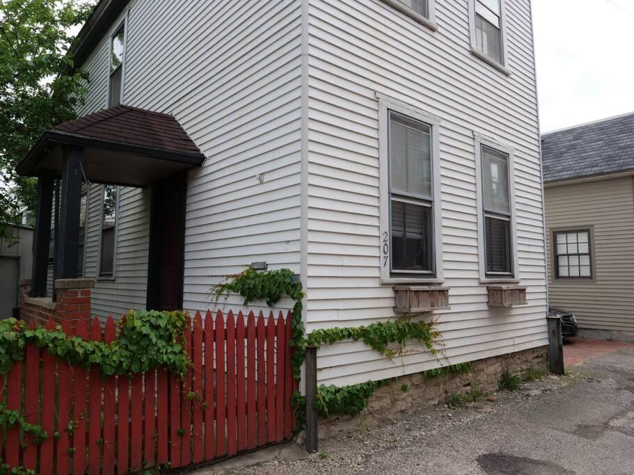 ein weißes Haus mit einem roten Zaun davor in der Unterkunft Historic German Village Home/A+ Downtown Location in Columbus