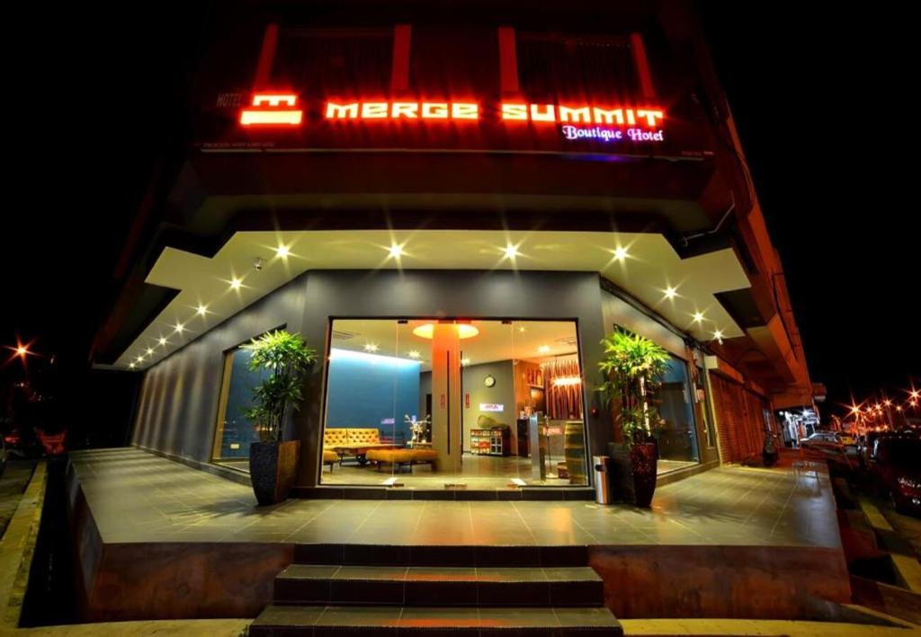 安顺Merge Summit by Secoms的上面有 ⁇ 虹灯标志的建筑